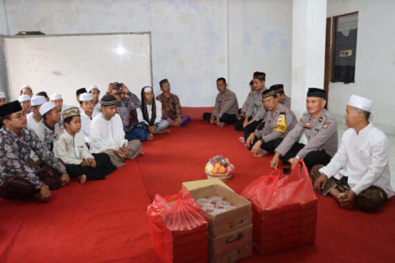 Anggota Polres Batu saat membagikan takjil dan bingkisan kepada anak yatim piatu di Ponpes Ar Ridlwan, Jumat (7/3/2025)